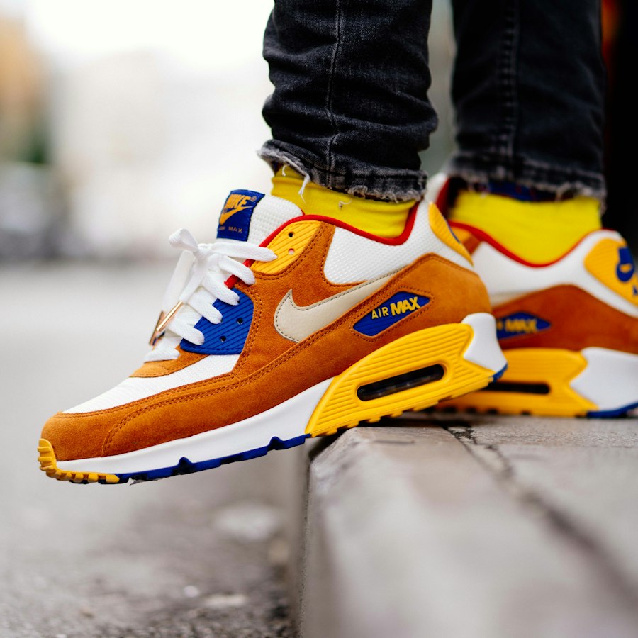 Orange, yellow and blue suede runners worn on a kerb
